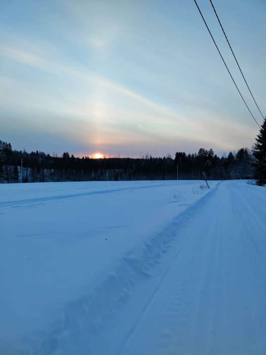 talvinen tie, ja auringon paistetta näkyy