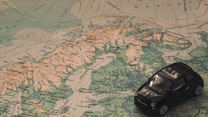 Kuvituskuva, jossa musta leluauto kartan päällä Suomen kohdalla.